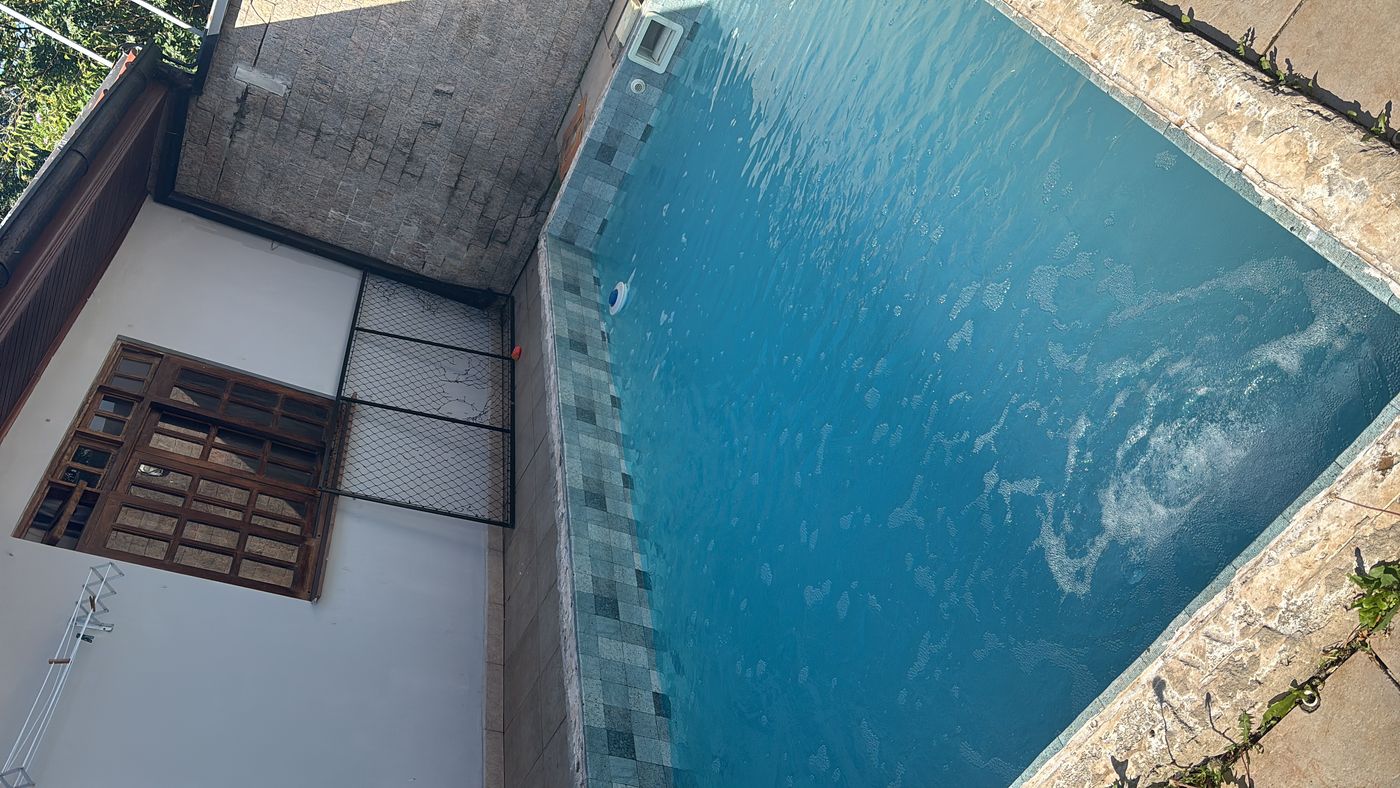 A mesma piscina de alvenaria com a água azul, depois do tratamento